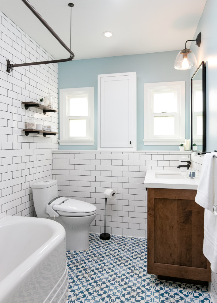 Inredning av ett klassiskt litet vit vitt badrum, med skåp i shakerstil, skåp i mellenmörkt trä, ett hörnbadkar, en dusch/badkar-kombination, vit kakel, tunnelbanekakel, blå väggar, klinkergolv i porslin, ett undermonterad handfat, bänkskiva i kvarts, blått golv, dusch med duschdraperi och en toalettstol med hel cisternkåpa