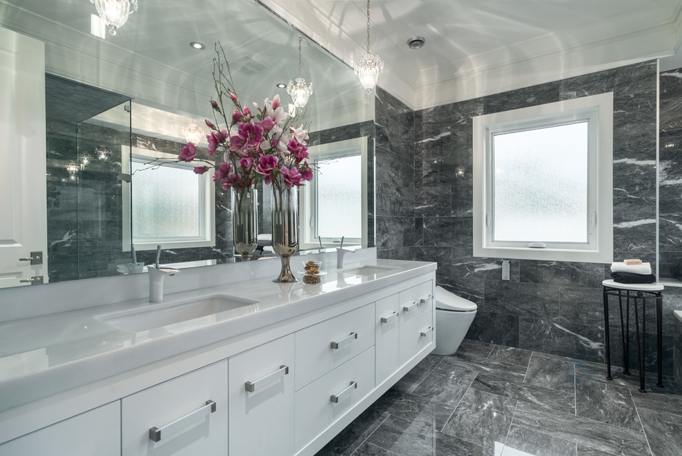 Inredning av ett modernt stort en-suite badrum, med släta luckor, vita skåp, ett platsbyggt badkar, en dusch i en alkov, en bidé, svart kakel, svart och vit kakel, grå kakel, stenkakel, marmorgolv, ett undermonterad handfat, bänkskiva i akrylsten, grått golv och dusch med gångjärnsdörr