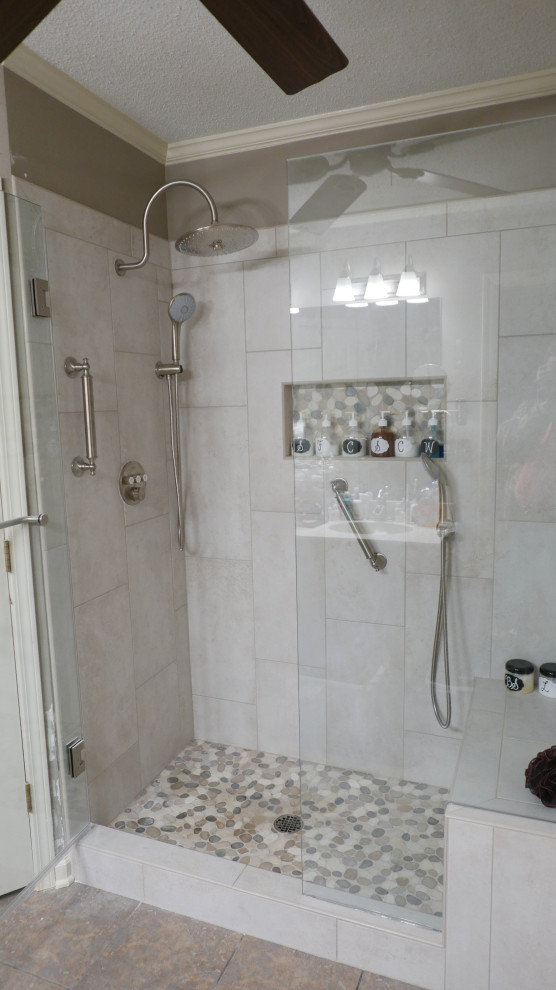 Idée de décoration pour une douche en alcôve principale tradition de taille moyenne avec un carrelage beige, des carreaux de porcelaine et une cabine de douche à porte battante.