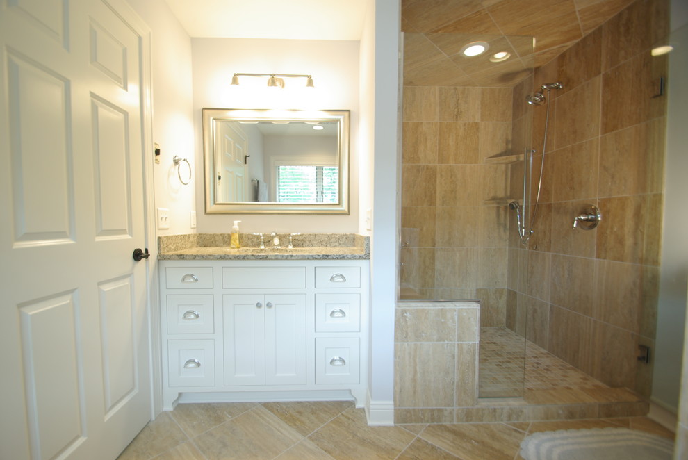 Cette image montre une salle de bain traditionnelle en bois foncé de taille moyenne avec un lavabo encastré, un placard à porte plane, un plan de toilette en granite, un carrelage beige, des carreaux de porcelaine, un mur blanc et un sol en carrelage de porcelaine.