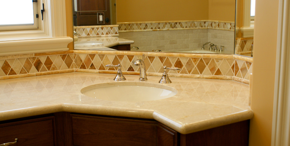 Foto på ett mellanstort vintage badrum, med ett undermonterad handfat, släta luckor, skåp i mörkt trä, marmorbänkskiva, flerfärgad kakel, stenkakel, orange väggar och ett platsbyggt badkar