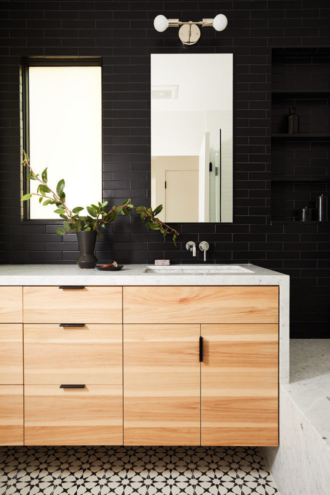 Свежая идея для дизайна: ванная комната в современном стиле с плоскими фасадами, черной плиткой, керамической плиткой, белыми стенами, полом из цементной плитки, врезной раковиной и мраморной столешницей - отличное фото интерьера