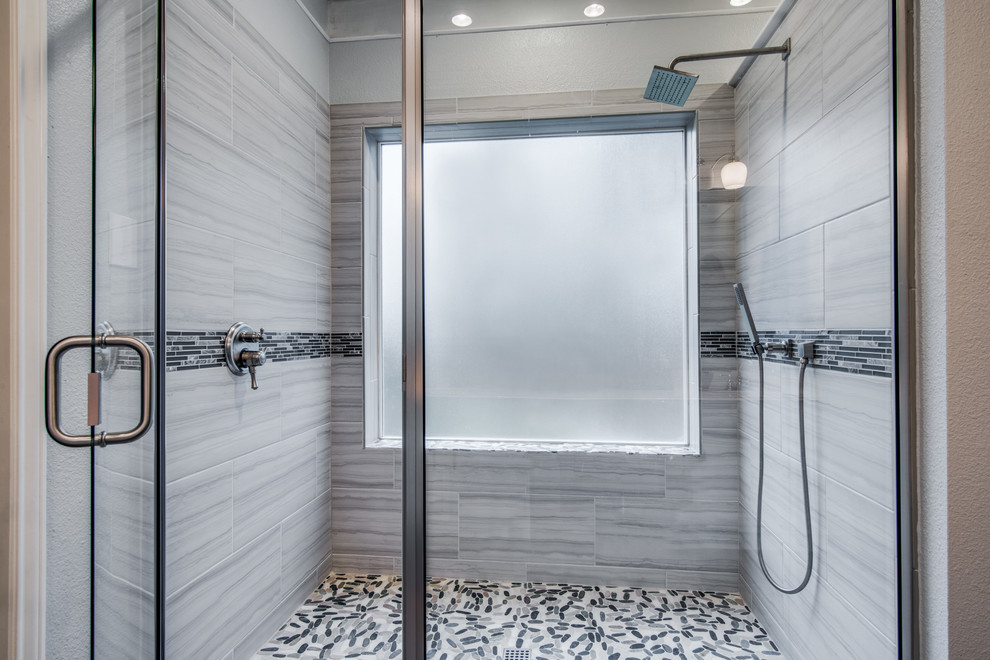 Example of a mid-sized minimalist master gray tile and ceramic tile pebble tile floor and gray floor alcove shower design in Austin with gray walls and a hinged shower door