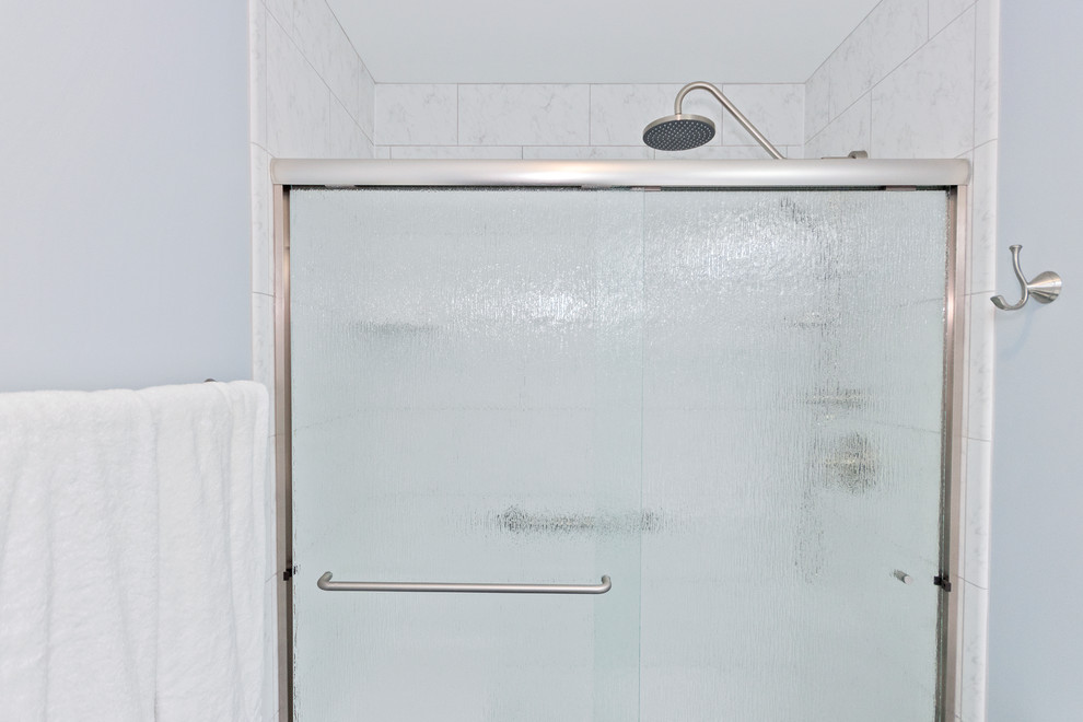 Idée de décoration pour une salle de bain tradition de taille moyenne avec un placard à porte shaker, des portes de placard blanches, WC séparés, un carrelage blanc, des carreaux de céramique, un mur bleu, un sol en carrelage de céramique, un lavabo encastré, un plan de toilette en quartz modifié, un sol gris, une cabine de douche à porte coulissante et un plan de toilette blanc.