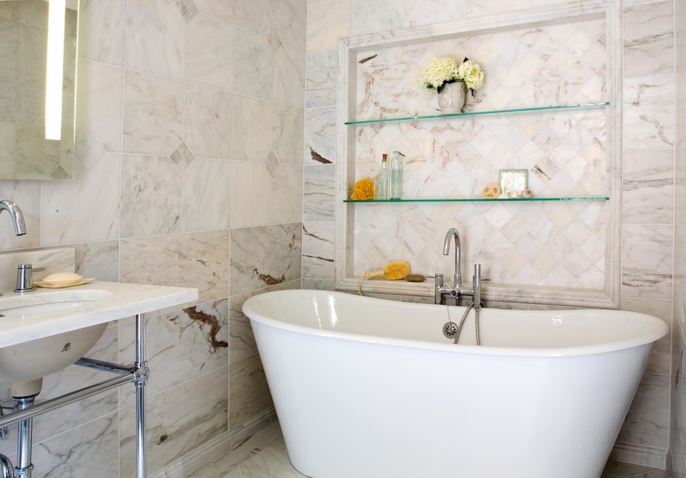 Immagine di una stanza da bagno padronale tradizionale di medie dimensioni con lavabo a consolle, vasca freestanding, piastrelle in pietra, pavimento in marmo, piastrelle bianche e top in marmo