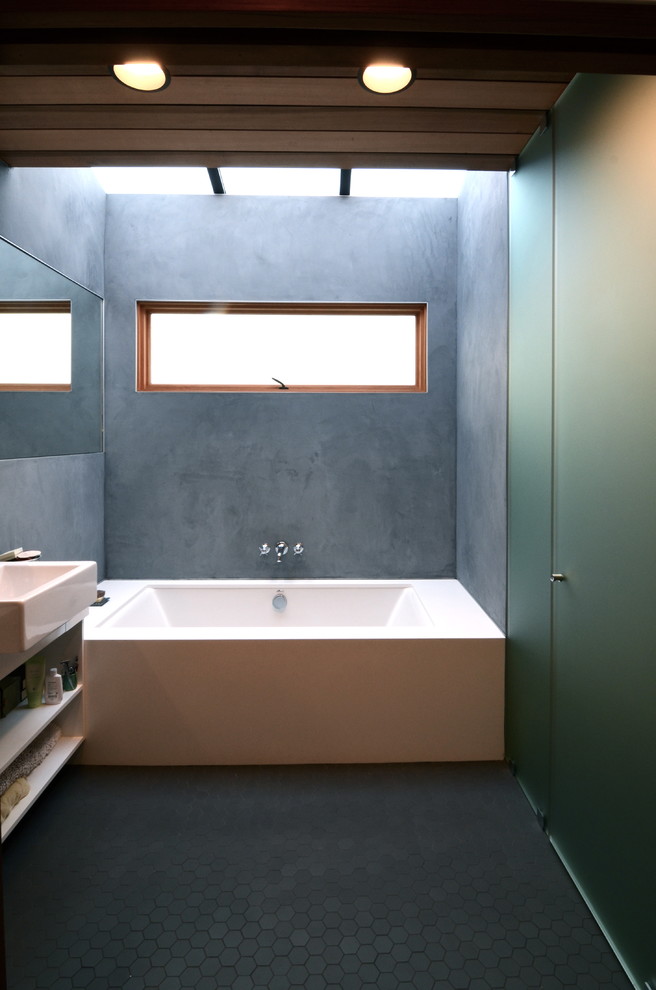 サンフランシスコにある小さなおしゃれなマスターバスルーム (ドロップイン型浴槽、マルチカラーの壁、壁付け型シンク、青い床、ベージュのカウンター) の写真