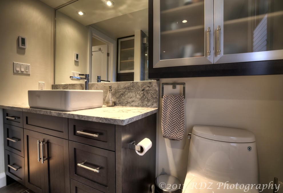 Ejemplo de cuarto de baño clásico renovado con lavabo sobreencimera, armarios estilo shaker, puertas de armario grises, encimera de granito, combinación de ducha y bañera y sanitario de una pieza