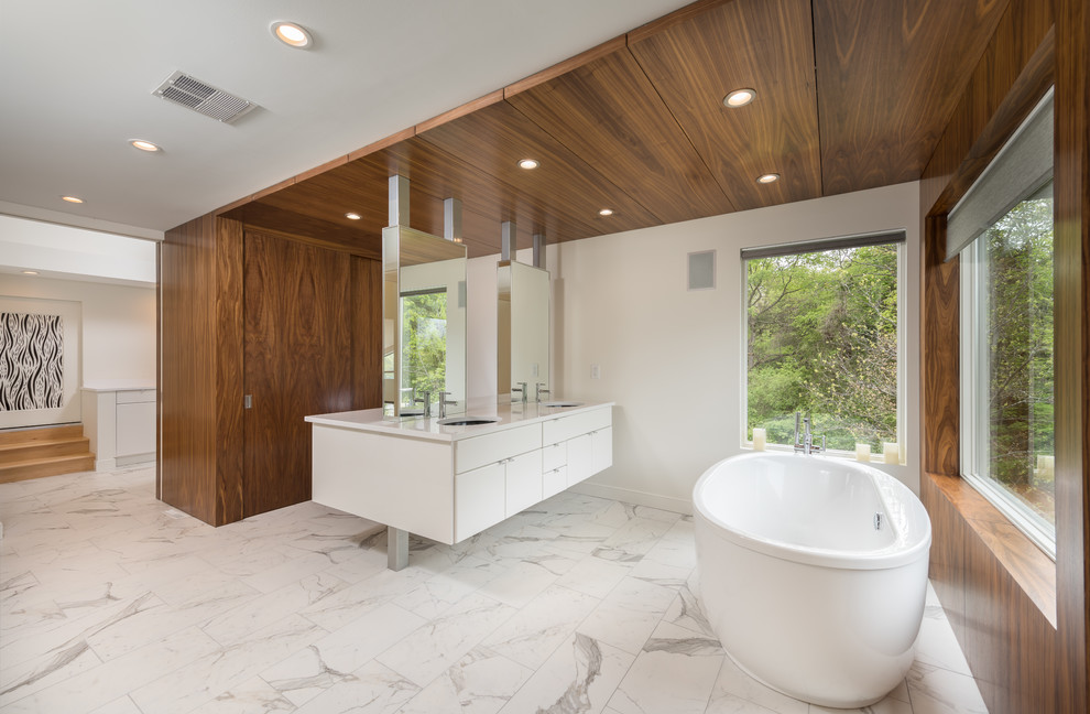 Стильный дизайн: большая главная ванная комната в стиле модернизм с плоскими фасадами, белыми фасадами, отдельно стоящей ванной, открытым душем, унитазом-моноблоком, белой плиткой, керамогранитной плиткой, белыми стенами, полом из керамогранита, врезной раковиной, столешницей из искусственного кварца, белым полом и открытым душем - последний тренд