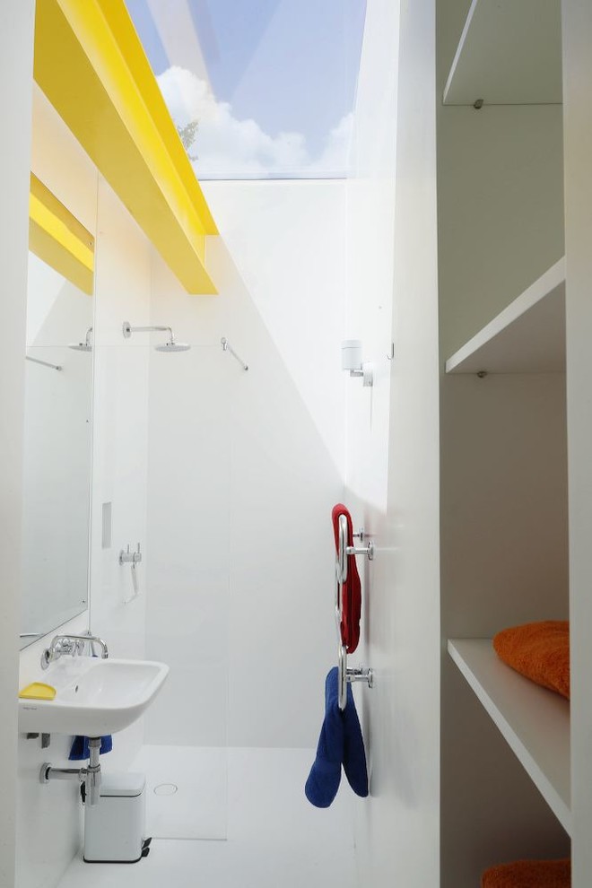 Foto på ett mellanstort funkis badrum med dusch, med öppna hyllor, vita skåp, vita väggar, vitt golv, med dusch som är öppen, vit kakel och ett väggmonterat handfat