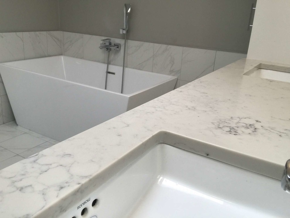 Inspiration for a large contemporary master white tile and porcelain tile porcelain tile and white floor bathroom remodel in Dallas with shaker cabinets, white cabinets, gray walls, an undermount sink, quartzite countertops and a hinged shower door
