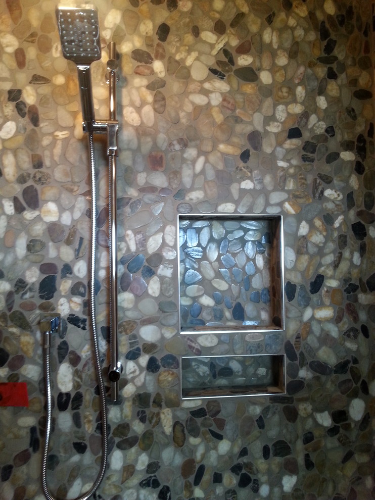Large rustic ensuite bathroom in Toronto with an alcove shower, multi-coloured tiles, pebble tiles and pebble tile flooring.
