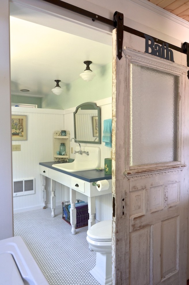 Réalisation d'une salle de bain tradition avec des portes de placard blanches, WC séparés, un mur vert et un lavabo posé.