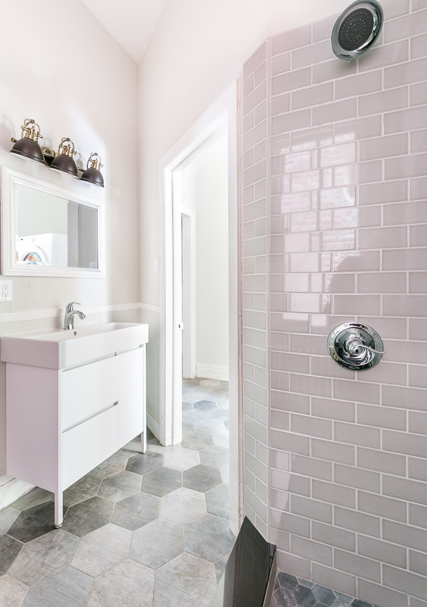 Ejemplo de cuarto de baño clásico renovado con armarios con paneles lisos, puertas de armario blancas, baldosas y/o azulejos rosa, baldosas y/o azulejos de cemento, paredes grises, suelo de azulejos de cemento, aseo y ducha, lavabo integrado y suelo gris