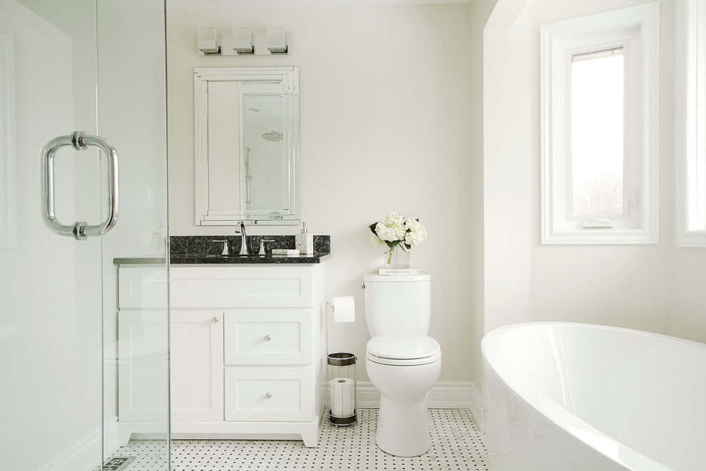 Пример оригинального дизайна: главная ванная комната в классическом стиле с столешницей из гранита, отдельно стоящей ванной и паркетным полом среднего тона