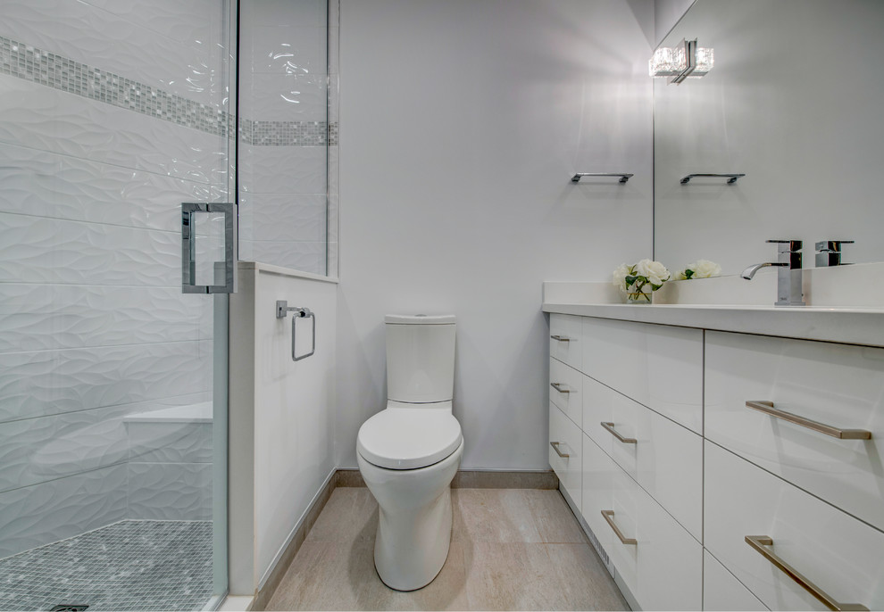 Inspiration pour une salle de bain design en bois clair de taille moyenne avec un placard à porte plane, WC à poser, un mur beige, un sol en carrelage de porcelaine, un lavabo encastré, un sol beige, une cabine de douche à porte battante, un carrelage blanc et un plan de toilette en surface solide.