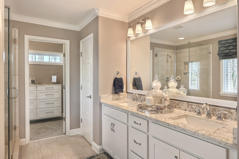 Klassisk inredning av ett stort en-suite badrum, med skåp i shakerstil, vita skåp, ett fristående badkar, en hörndusch, grå kakel, porslinskakel, grå väggar, klinkergolv i porslin, ett undermonterad handfat och granitbänkskiva