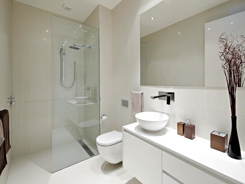 Modern inredning av ett mellanstort badrum med dusch, med släta luckor, vita skåp, bänkskiva i kvarts, en vägghängd toalettstol, porslinskakel, vita väggar, klinkergolv i porslin, ett fristående handfat och vit kakel