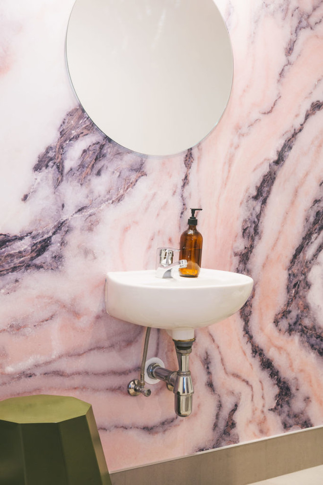 オークランドにある小さなシャビーシック調のおしゃれなトイレ・洗面所 (ピンクのタイル、ピンクの壁、壁付け型シンク) の写真