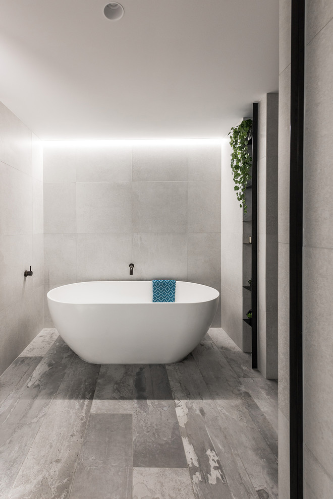 This is an example of a small contemporary ensuite bathroom in Melbourne with flat-panel cabinets, white cabinets, a freestanding bath, a walk-in shower, a one-piece toilet, grey tiles, porcelain tiles, grey walls, porcelain flooring, a vessel sink, engineered stone worktops, grey floors and an open shower.