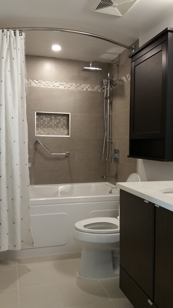 Cette photo montre une salle de bain tendance en bois foncé avec un carrelage gris, un carrelage blanc, des carreaux de porcelaine, un mur beige, un lavabo encastré, un plan de toilette en surface solide, un placard à porte shaker, une baignoire en alcôve, un combiné douche/baignoire, WC séparés et un sol en carrelage de céramique.
