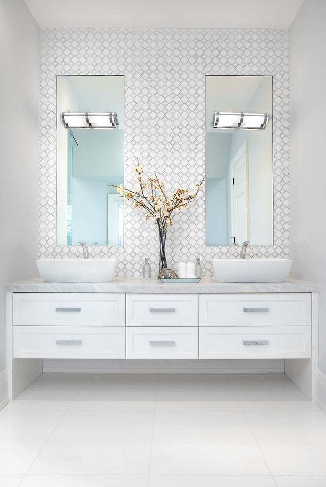 Пример оригинального дизайна: большая главная ванная комната в стиле неоклассика (современная классика) с белыми фасадами, серой плиткой, белой плиткой, плиткой мозаикой, белыми стенами, настольной раковиной, белым полом, фасадами с утопленной филенкой, отдельно стоящей ванной, угловым душем, унитазом-моноблоком, мраморным полом, мраморной столешницей и душем с распашными дверями