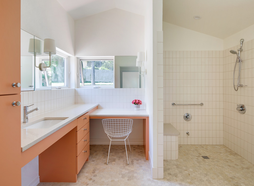 Midcentury bathroom in Austin with flat-panel cabinets, orange cabinets, a built-in shower, white tiles, white walls, a submerged sink, beige floors, an open shower and white worktops.
