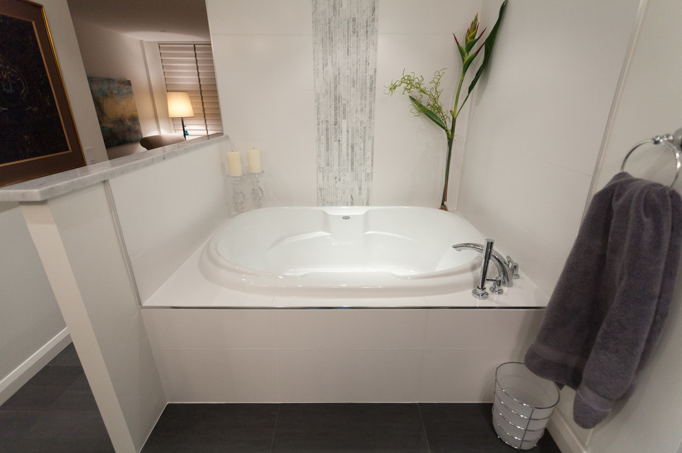 カルガリーにある高級な小さなトランジショナルスタイルのおしゃれなマスターバスルーム (ドロップイン型浴槽、白いタイル、石タイル、白い壁、磁器タイルの床) の写真