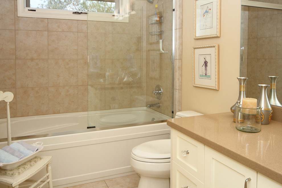 Cette image montre une salle de bain traditionnelle de taille moyenne pour enfant avec un lavabo encastré, un placard à porte shaker, des portes de placard jaunes, un plan de toilette en quartz modifié, une baignoire en alcôve, un combiné douche/baignoire, WC à poser, un carrelage beige, des carreaux de porcelaine, un mur beige et un sol en carrelage de porcelaine.