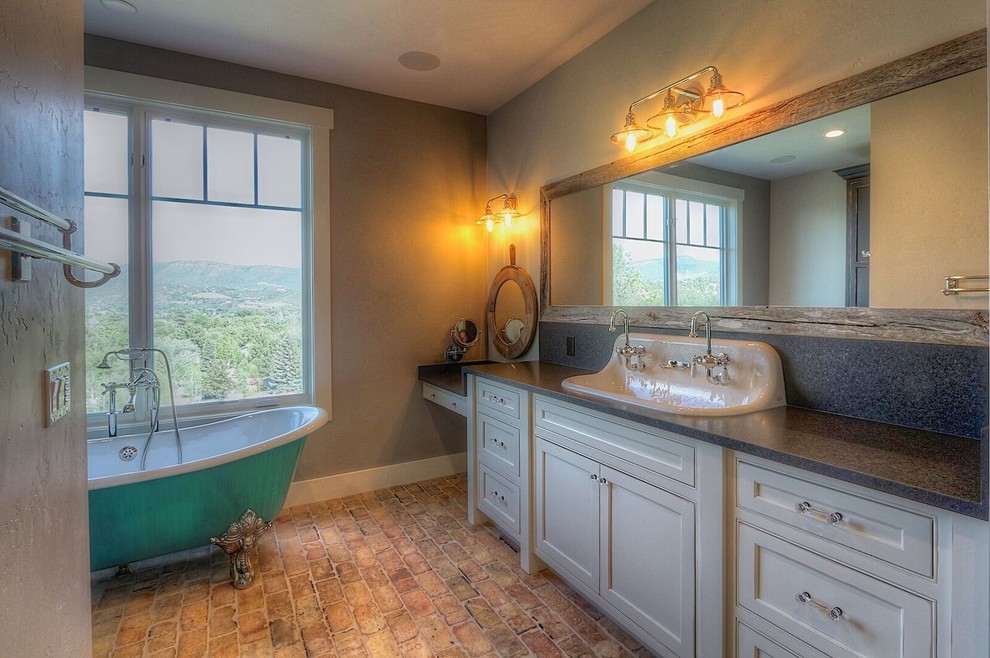 Foto på ett stort lantligt grå en-suite badrum, med luckor med profilerade fronter, vita skåp, ett badkar med tassar, beige väggar, tegelgolv, ett avlångt handfat, granitbänkskiva och flerfärgat golv