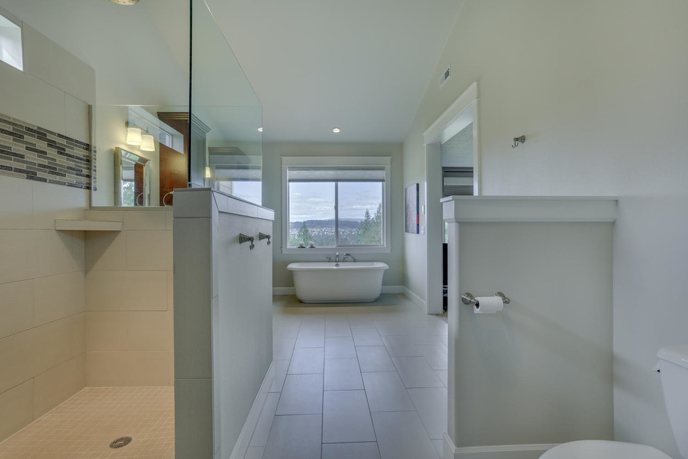 Diseño de cuarto de baño principal de estilo americano grande con bañera exenta, ducha a ras de suelo y paredes grises