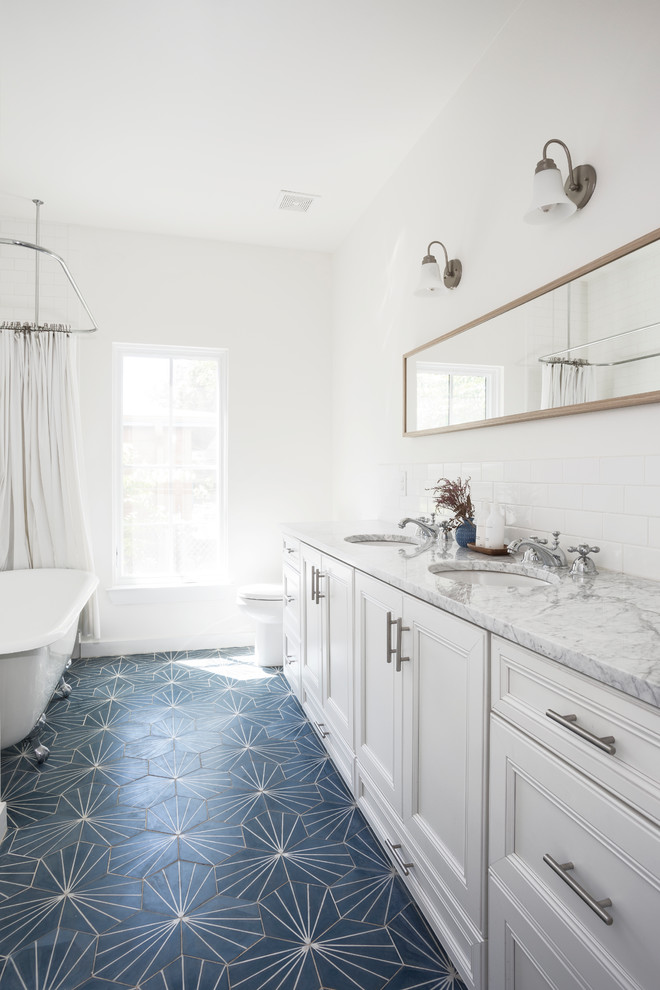 Example of a mid-sized farmhouse kids' white tile and subway tile blue floor claw-foot bathtub design in Austin with white cabinets, a two-piece toilet, white walls, an undermount sink, marble countertops, a hinged shower door, beaded inset cabinets and gray countertops
