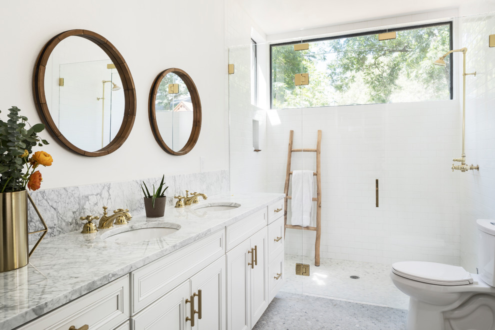 Example of a mid-sized country master white tile and subway tile mosaic tile floor and gray floor walk-in shower design in Austin with white cabinets, a two-piece toilet, white walls, an undermount sink, marble countertops, a hinged shower door, beaded inset cabinets and gray countertops