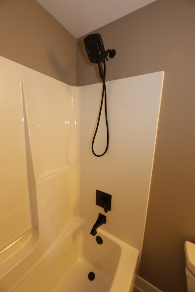 Design ideas for a medium sized classic shower room bathroom in Chicago with shaker cabinets, white cabinets, an alcove bath, a shower/bath combination, a two-piece toilet, grey walls, vinyl flooring, a submerged sink and granite worktops.