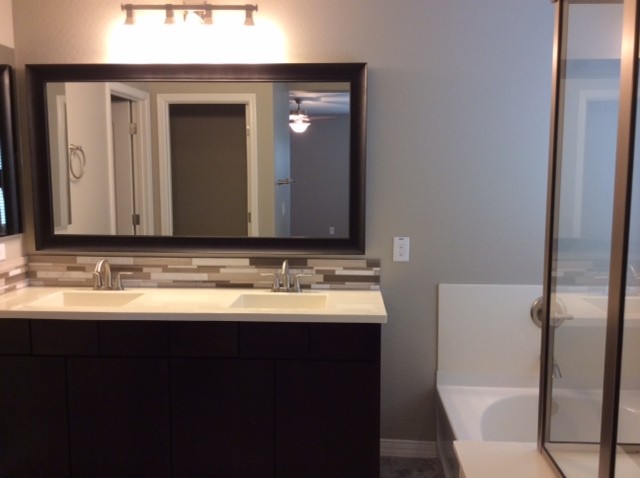 Medium sized contemporary ensuite bathroom in Phoenix with an integrated sink, flat-panel cabinets, dark wood cabinets, engineered stone worktops, a corner shower, a one-piece toilet, metro tiles, beige walls and porcelain flooring.