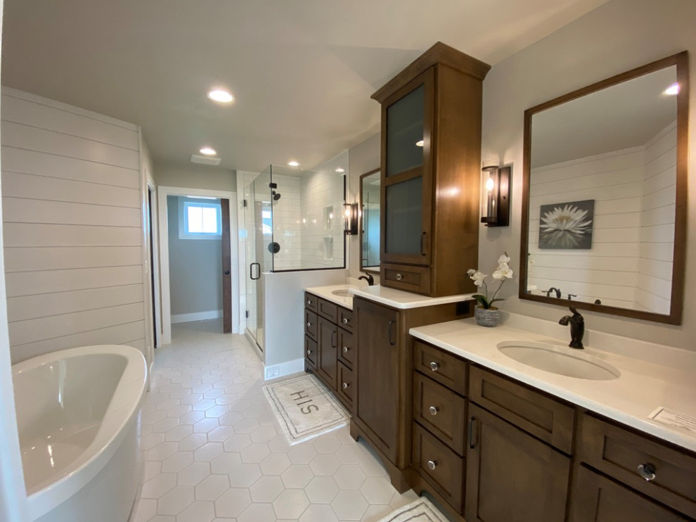 Inredning av ett amerikanskt stort vit vitt en-suite badrum, med vita skåp, ett fristående badkar, en hörndusch, en toalettstol med separat cisternkåpa, grå väggar, cementgolv, ett integrerad handfat, bänkskiva i kvarts, vitt golv och dusch med gångjärnsdörr
