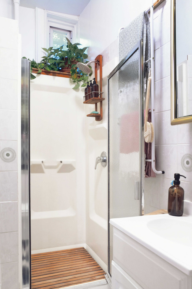 ニューヨークにある低価格の小さなミッドセンチュリースタイルのおしゃれな浴室 (シェーカースタイル扉のキャビネット、白いキャビネット、アルコーブ型シャワー、マルチカラーのタイル、セラミックタイル、セラミックタイルの床、珪岩の洗面台、マルチカラーの床、開き戸のシャワー、洗面台1つ、造り付け洗面台) の写真