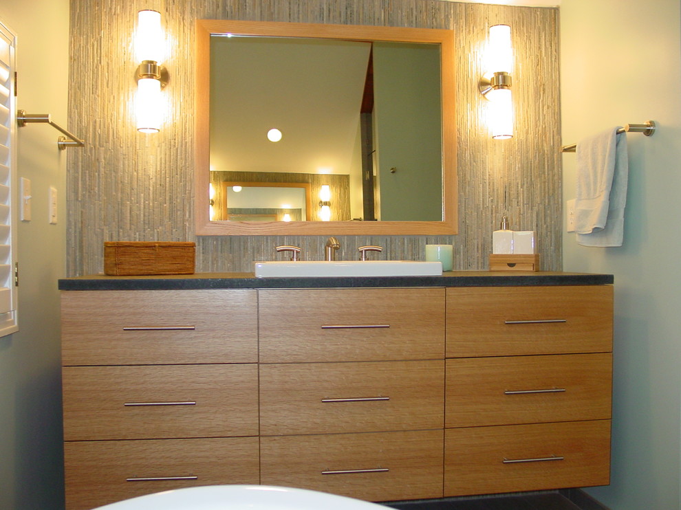 Immagine di una stanza da bagno moderna di medie dimensioni con ante lisce, ante in legno chiaro, pareti blu, lavabo a bacinella e top in saponaria