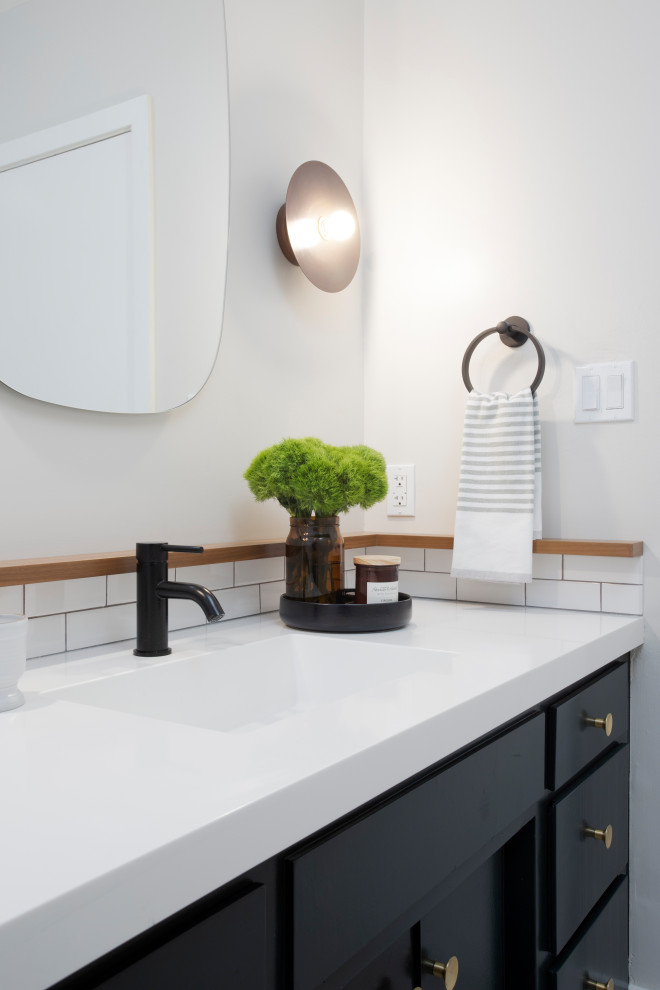 Medium sized midcentury family bathroom in Los Angeles with flat-panel cabinets, black cabinets, a shower/bath combination, a one-piece toilet, white tiles, metro tiles, white walls, an integrated sink, engineered stone worktops, grey floors, a shower curtain, white worktops, a single sink and a built in vanity unit.