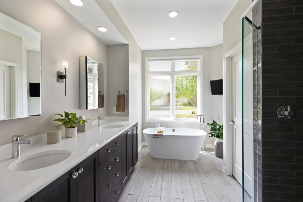 Example of a transitional gray floor and double-sink bathroom design in Minneapolis with shaker cabinets, dark wood cabinets, gray walls, an undermount sink, white countertops and a built-in vanity