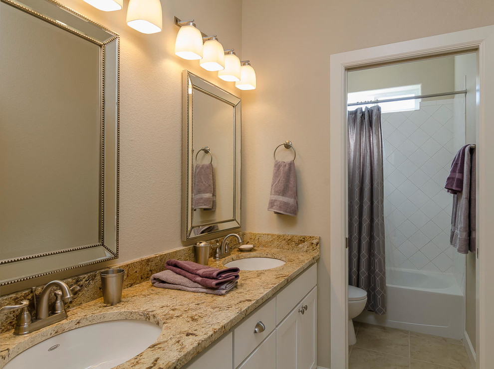 Inspiration for a medium sized traditional ensuite bathroom in Albuquerque with shaker cabinets, white cabinets, a built-in bath, an alcove shower, a two-piece toilet, beige tiles, ceramic tiles, beige walls, travertine flooring, a submerged sink and granite worktops.