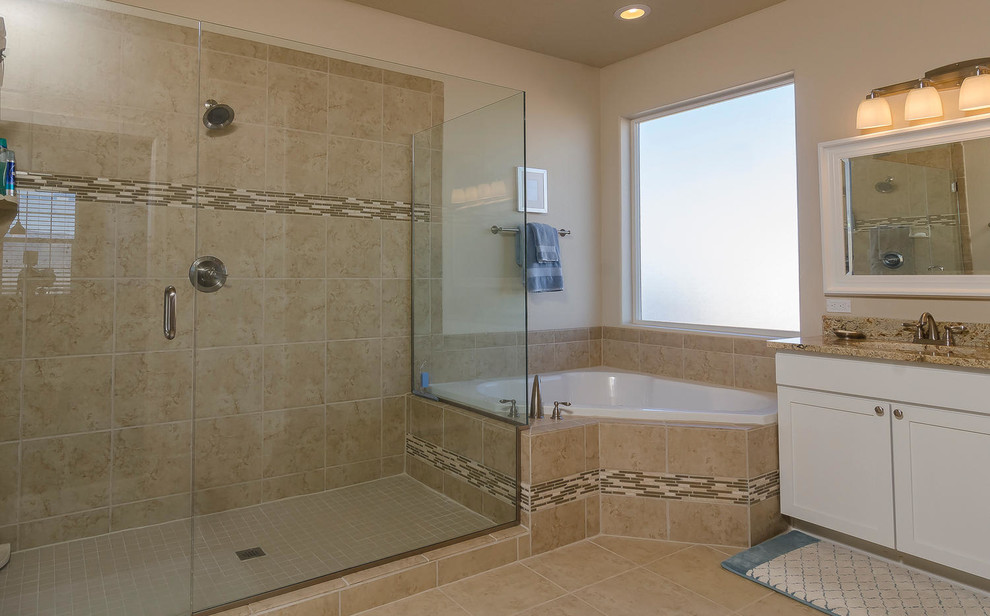 This is an example of a medium sized classic ensuite bathroom in Albuquerque with beige walls, travertine flooring, a built-in bath, an alcove shower, a two-piece toilet, beige tiles, ceramic tiles, a submerged sink, shaker cabinets, white cabinets and granite worktops.