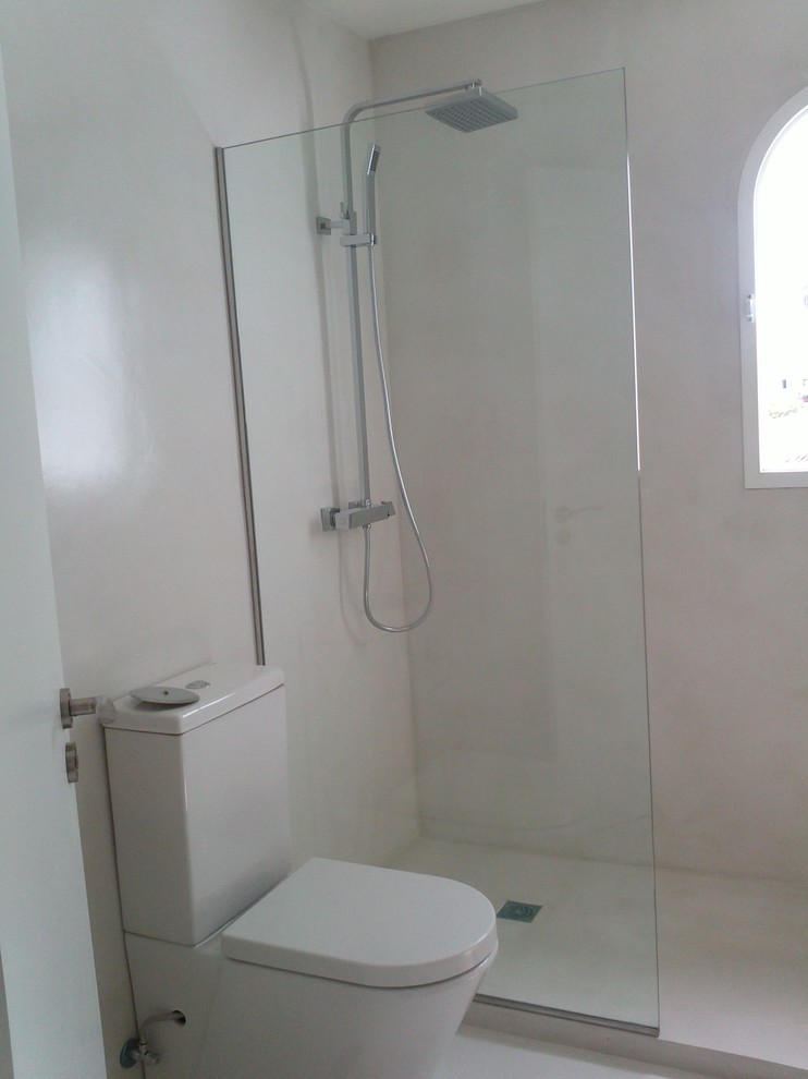 Imagen de cuarto de baño contemporáneo pequeño con ducha a ras de suelo, sanitario de dos piezas, paredes beige, aseo y ducha y microcemento