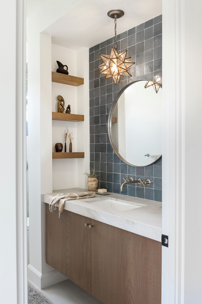 Country Badezimmer mit flächenbündigen Schrankfronten, hellbraunen Holzschränken, grauen Fliesen, weißer Wandfarbe, Unterbauwaschbecken, grauem Boden und weißer Waschtischplatte in San Diego