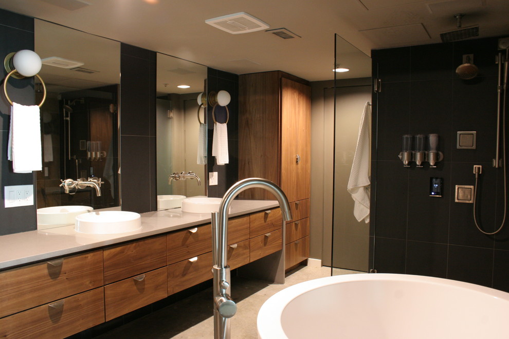 Foto på ett litet vintage grå en-suite badrum, med släta luckor, skåp i mellenmörkt trä, ett japanskt badkar, en öppen dusch, en bidé, svart kakel, stenkakel, grå väggar, betonggolv, ett integrerad handfat, bänkskiva i kvartsit, grått golv och dusch med gångjärnsdörr