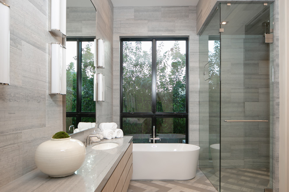Inredning av ett modernt stort grå grått en-suite badrum, med släta luckor, skåp i ljust trä, ett fristående badkar, en hörndusch, grå kakel, flerfärgat golv, dusch med gångjärnsdörr och ett undermonterad handfat