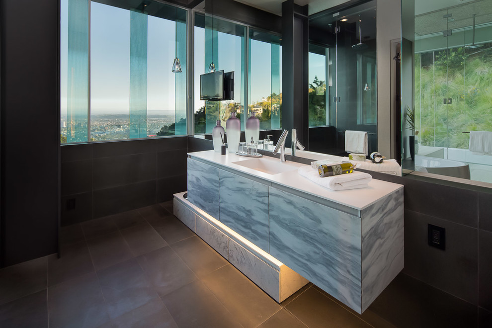 Exempel på ett stort modernt en-suite badrum, med släta luckor, grå skåp, ett fristående badkar, brun kakel, stenkakel, bruna väggar, skiffergolv, ett integrerad handfat och bänkskiva i kvarts