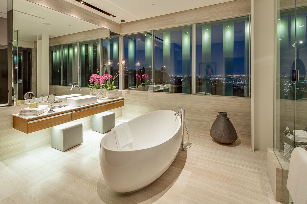 Cette photo montre une grande salle de bain principale moderne en bois brun avec un placard à porte plane, une baignoire indépendante, un espace douche bain, un mur beige, un sol en vinyl, une vasque et un plan de toilette en quartz modifié.