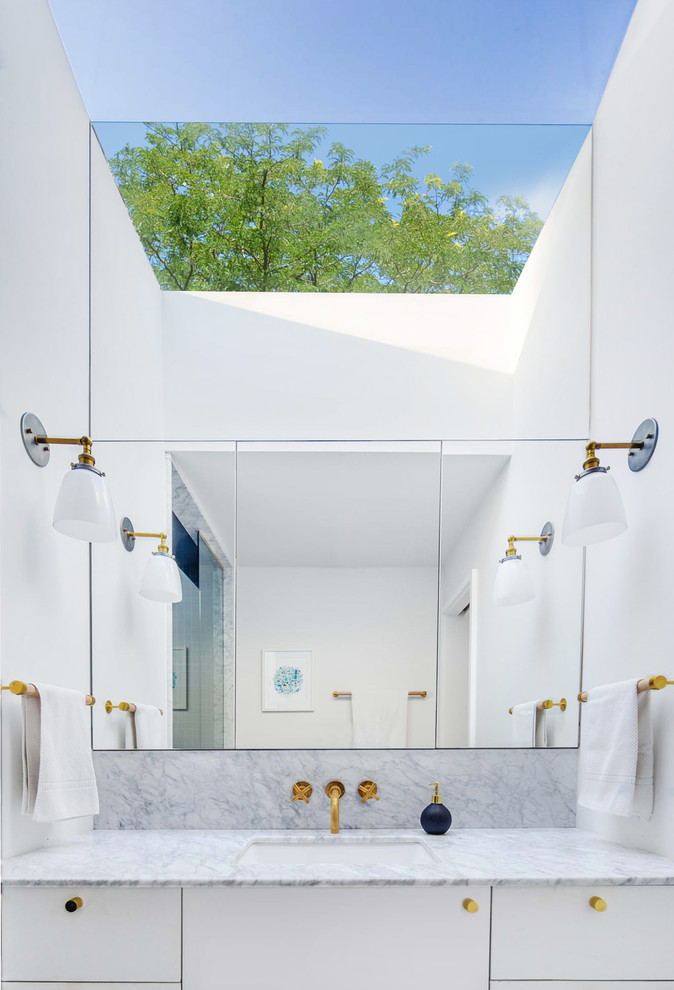 Inspiration pour une petite douche en alcôve principale minimaliste avec WC suspendus, des dalles de pierre, un mur blanc, un sol en marbre, un lavabo encastré, un plan de toilette en marbre, un placard à porte plane et des portes de placard blanches.