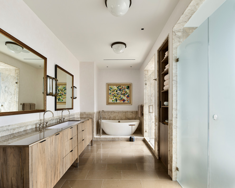 Пример оригинального дизайна: большая главная ванная комната в современном стиле с плоскими фасадами, фасадами цвета дерева среднего тона, отдельно стоящей ванной, бежевой плиткой, белыми стенами, полом из известняка, врезной раковиной, столешницей из известняка, бежевым полом, душем с распашными дверями, бежевой столешницей и душем в нише