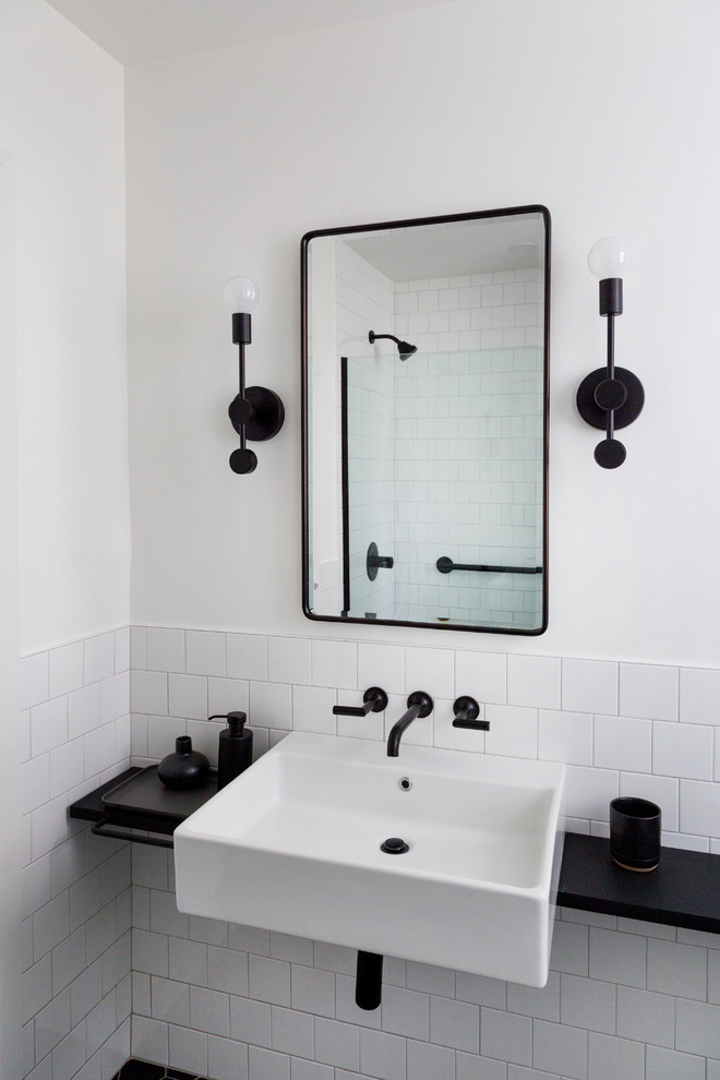 Пример оригинального дизайна: маленькая главная ванная комната в стиле модернизм с открытым душем, раздельным унитазом, белой плиткой, керамической плиткой, белыми стенами, полом из керамогранита, подвесной раковиной, черным полом, открытым душем и черной столешницей для на участке и в саду